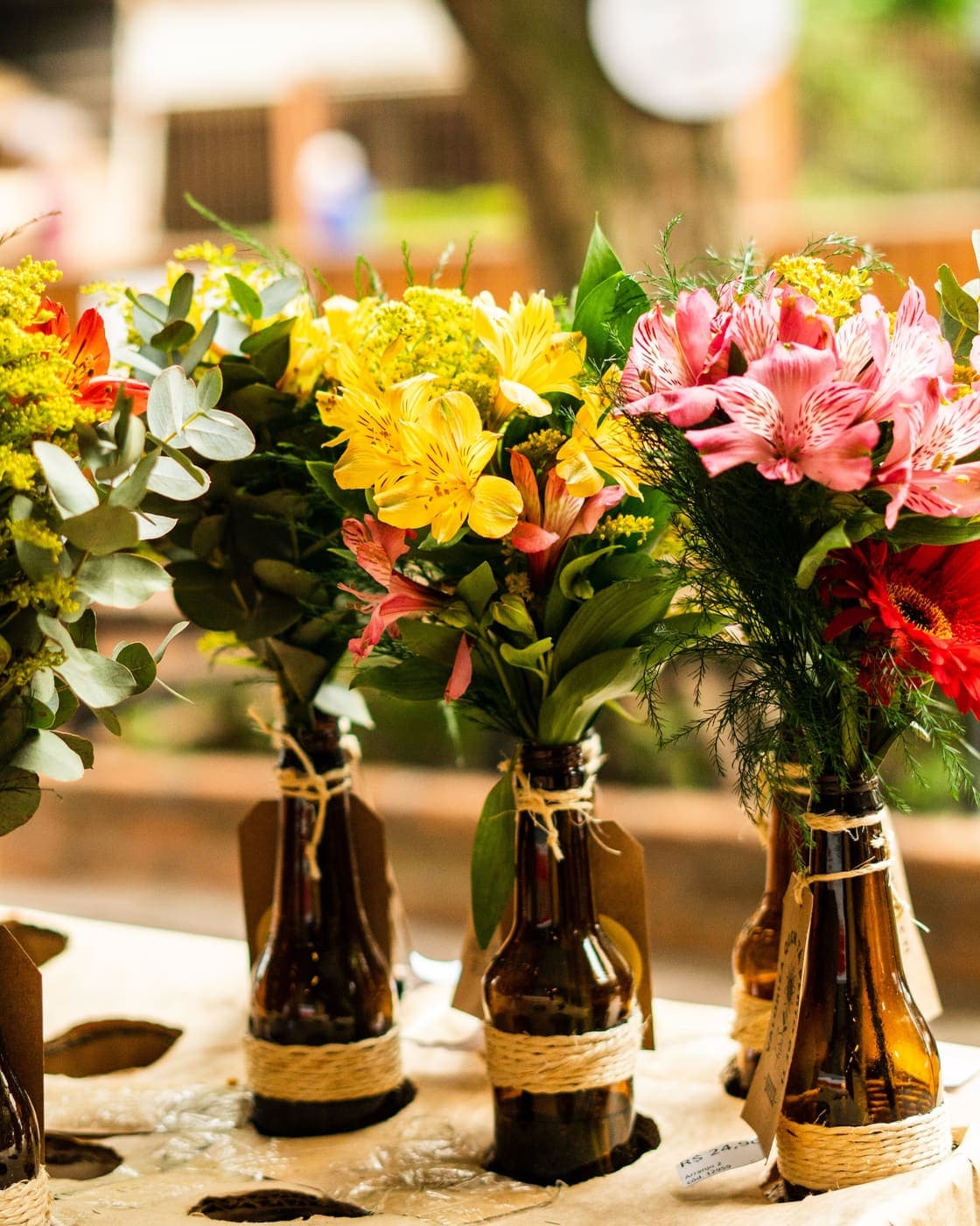 Buquês de flores em garrafas de vidro na entrada do Brasco Florêncio.