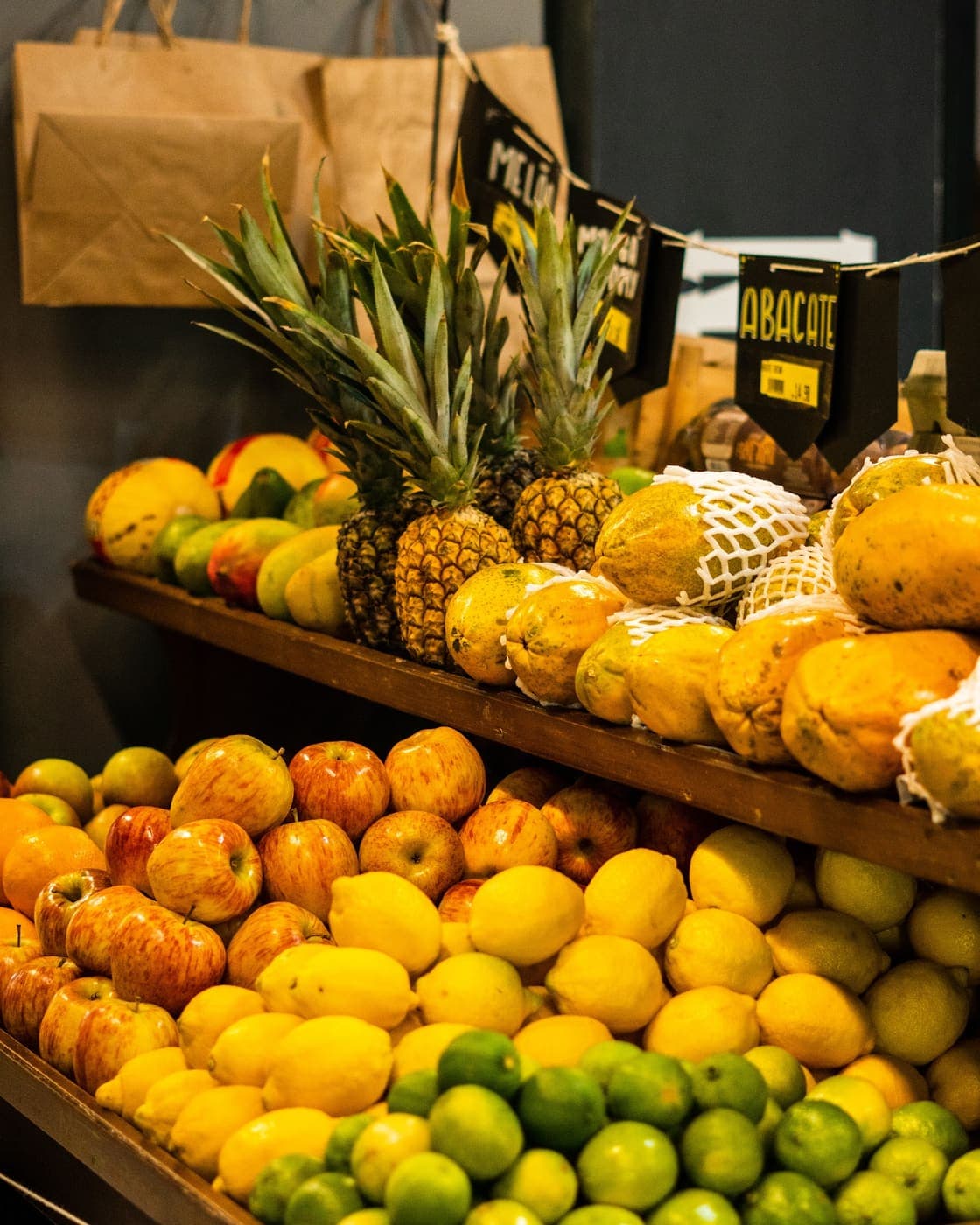 Banca de frutas do Brasco Florêncio: abacaxi, mamão, maçãs, limões e abacates.